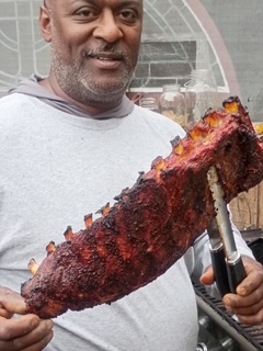 Cook holding freshly smoked ribs